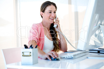 smiling buiness woman on the phone in her office