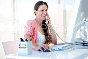 smiling buiness woman on the phone in her office