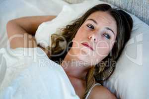 tired woman lying in bed staring into space
