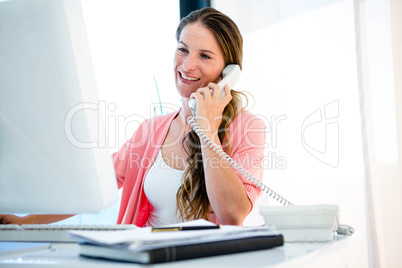 Smiling businesswoman on the phone in her office