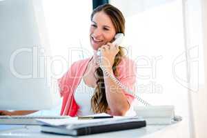 Smiling businesswoman on the phone in her office