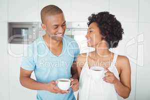 Smiling couple holding mugs