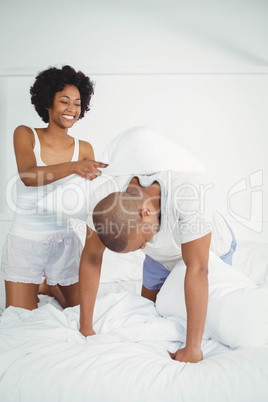 Happy couple having a pillow fight