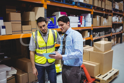 Manager showing tablet to worker