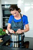 smiling woman cooking on the stove top