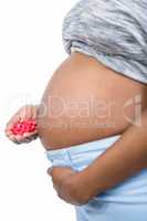 Pregnant woman holding pills in her hand