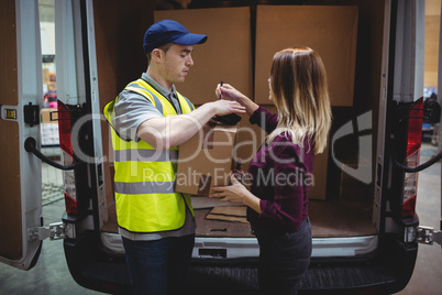 Woman signing on device to delivery parcel