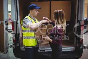 Woman signing on device to delivery parcel