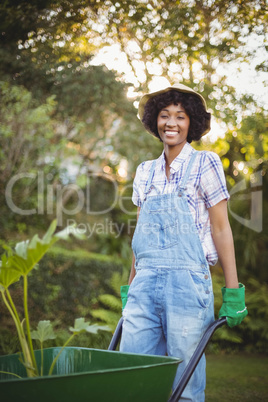 Smiling woman pushing wheelbarrow