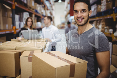 Smiling man carrying box