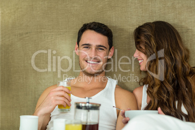 Young couple having breakfast on bed