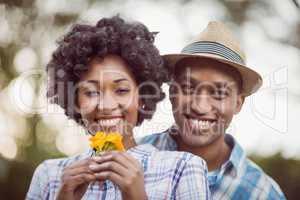 Smiling couple holding yellow flowers