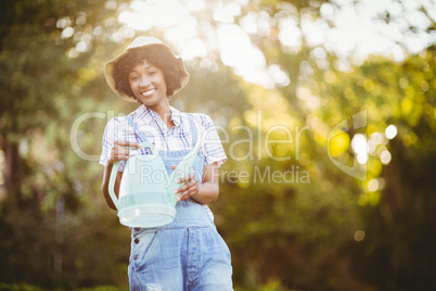 Smiling woman watering plants