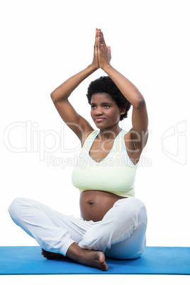 Pregnant woman meditating on mat