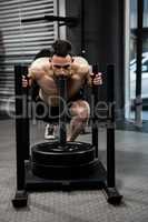 Shirtless man pushing heavy weights