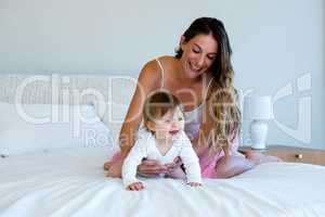 smiling woman holding a crawling baby