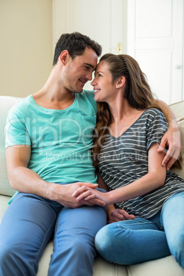 Young couple cuddling on sofa