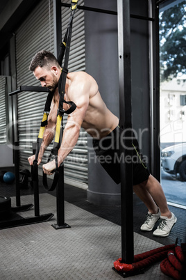 Shirtless man hanging at the rope