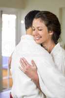 Young couple in bathrobe cuddling each other