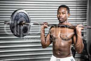 Shirtless man lifting barbell