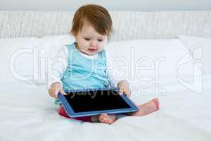 adorable baby holding aa tablet computer