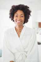 Pretty woman in bath robe smiling at the camera