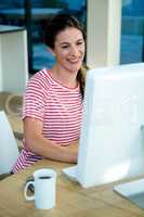 smiling businesswoman typing on her computer