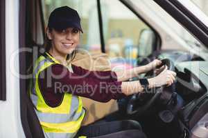 Delivery driver driving van with parcels on seat