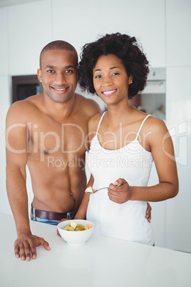 Happy couple  eating fruit together in the kitchen