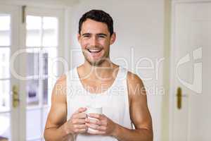 Young man smiling and holding coffee