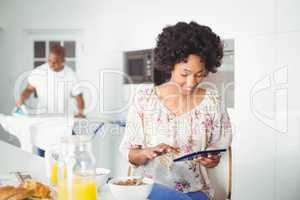 Brunette using tablet in kitchen