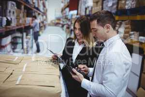 Warehouse managers looking at clipboard