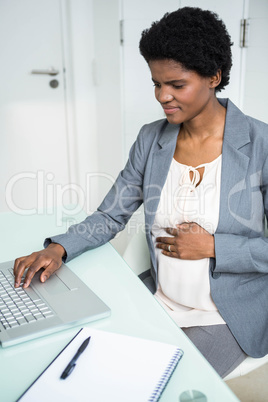 Pregnant businesswoman working on laptop