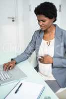 Pregnant businesswoman working on laptop