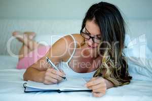 smiling woman with glasses writing in a book