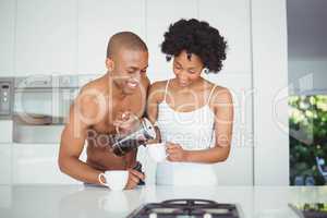 Happy couple drinking coffee in the kitchen