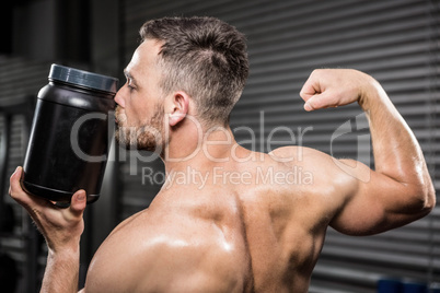 Shirtless man showing biceps and kissing can