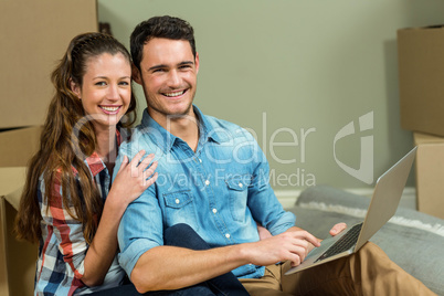 Young woman sitting on floor and using laptop