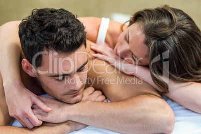 Young couple cuddling on bed