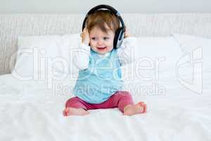smiling baby playing with a pair of headphones