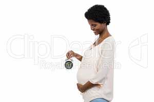 Pregnant woman holding an alarm clock