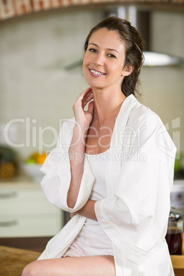 Portrait of beautiful woman sitting on worktop