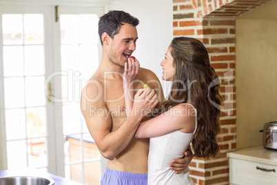 Young couple feeding fruits to each other