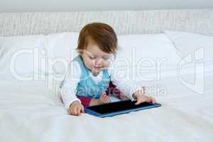 smiling baby playing with a tablet