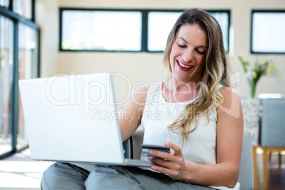 smiling woman on her laptop with credit card