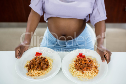 Pregnant woman with plate of pasta