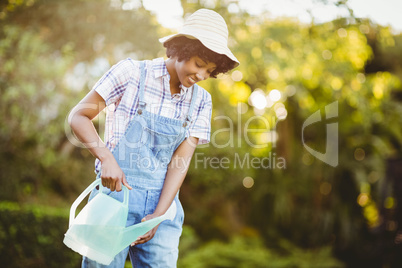 Smiling woman watering plants