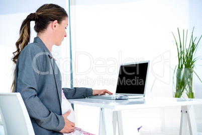 pregnantbusiness  woman typing on her laptop