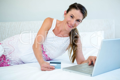 smiling woman on her laptop with credit card