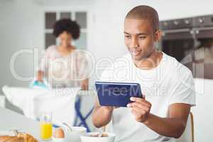 Young man using tablet in kitchen